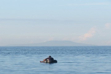 Young boy fishing in the ocean at Bali Eco Beach House